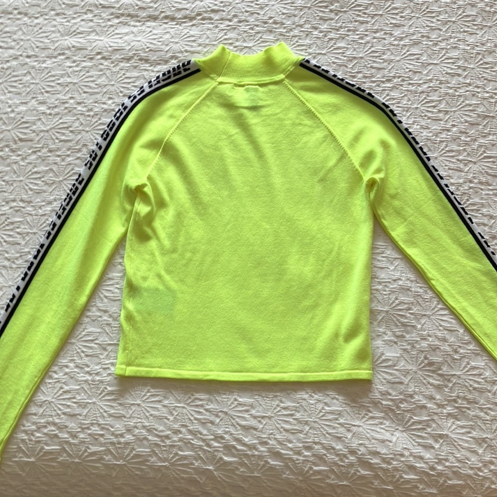 Bright green fun sweater with black and white Los Angeles 1999 down sleeves.